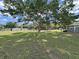 Spacious backyard with green grass and a large tree offering plenty of shade at 1534 Longbow Dr, Lakeland, FL 33810