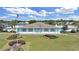 Charming single-story light blue home with a manicured lawn and welcoming front entrance with an American flag at 1534 Longbow Dr, Lakeland, FL 33810