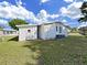 Rear view of a white single-story house, featuring a shed and an AC unit at 1534 Longbow Dr, Lakeland, FL 33810