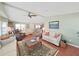 Well-lit living room with large windows, ceiling fan, and a comfortable seating arrangement at 1534 Longbow Dr, Lakeland, FL 33810