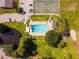 The aerial view highlights the pool, tennis courts, a pond, and surrounding green spaces at 1602 Eagle Pond Dr # 1602, Winter Haven, FL 33884