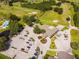 Aerial view of clubhouse, parking, pool, golf course, and surrounding green spaces at 1602 Eagle Pond Dr # 1602, Winter Haven, FL 33884