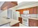 Traditional-style kitchen featuring warm wood cabinetry and white appliances at 1602 Eagle Pond Dr # 1602, Winter Haven, FL 33884