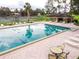 Community pool and cabana with tennis courts in background offer resort style living at 1602 Eagle Pond Dr # 1602, Winter Haven, FL 33884