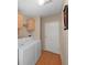 Functional laundry room with modern washer and dryer, overhead cabinets, and durable wood flooring at 1746 Fox Hill Dr, Lakeland, FL 33810