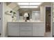 This bathroom has dual sinks with a large mirror with recessed lighting, shelves, and white cabinets at 195 E Conant St, Bartow, FL 33830