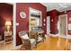 A secondary view of the bathroom hall area with hardwood floors, a small wicker chair, and a lamp at 195 E Conant St, Bartow, FL 33830