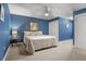 A blue bedroom with a neutral carpet and a large bed with a ceiling fan and a double closet at 195 E Conant St, Bartow, FL 33830