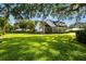 An expansive green lawn leads up to a lovely white home with a porch and elegant landscaping at 195 E Conant St, Bartow, FL 33830