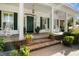 Close-up of the front entrance showcasing a brick walkway, potted plants, and rocking chairs at 195 E Conant St, Bartow, FL 33830