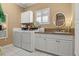 This laundry room has a sink, washer, dryer, and white cabinets with plenty of storage at 195 E Conant St, Bartow, FL 33830