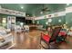 Large living room showcasing dark wood floors, hanging swings, and an array of comfortable wicker seating at 195 E Conant St, Bartow, FL 33830