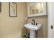 Elegant powder room featuring a pedestal sink, decorative mirror, and floral accents at 195 E Conant St, Bartow, FL 33830