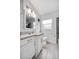 This bathroom includes a large mirror, granite vanity, and toilet, complete with a frosted window at 2020 Bassedena W Cir, Lakeland, FL 33805