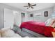 Cozy bedroom featuring a ceiling fan, neutral paint, carpet, and a bright red comforter on the bed at 2020 Bassedena W Cir, Lakeland, FL 33805