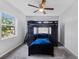 Bedroom with dark wood bunkbed, ceiling fan, and large window providing plenty of natural light at 2020 Bassedena W Cir, Lakeland, FL 33805