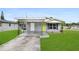 Charming single-story home with a grey exterior, well-maintained lawn, and a covered carport at 2020 Bassedena W Cir, Lakeland, FL 33805