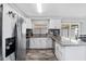 The kitchen has white cabinets, stainless appliances, and modern floors, perfect for cooking and gathering at 2020 Bassedena W Cir, Lakeland, FL 33805