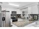 Bright kitchen features stainless steel appliances, granite countertops, white cabinets, and modern backsplash at 2020 Bassedena W Cir, Lakeland, FL 33805