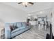 Open-concept living space with modern floors, a comfortable sofa, seamlessly connecting to the kitchen and dining areas at 2020 Bassedena W Cir, Lakeland, FL 33805