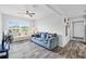 A cozy living room with a soft blue sofa, decorative pillows, and ample natural light, showcases stylish, comfy living at 2020 Bassedena W Cir, Lakeland, FL 33805