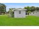 External view of the house exhibiting side lawn and a simple, painted facade at 2020 Bassedena W Cir, Lakeland, FL 33805