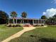 Charming clubhouse surrounded by a lush green lawn and vibrant tropical plants at 2055 S Floral Ave # 11, Bartow, FL 33830