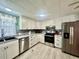 Modern kitchen featuring stainless steel appliances, stylish backsplash and sleek white cabinetry at 2055 S Floral Ave # 11, Bartow, FL 33830