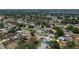 Expansive aerial view of a quiet neighborhood with mature trees and a glimpse of a serene lake in the distance at 210 Citrus Dr, Winter Haven, FL 33884