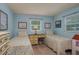 Bright bedroom with two beds, dresser and a center desk with artwork on the walls at 210 Citrus Dr, Winter Haven, FL 33884