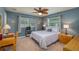 Charming bedroom with a comfortable bed, windows with blinds, and a ceiling fan at 210 Citrus Dr, Winter Haven, FL 33884