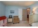 Bedroom featuring a sitting chair, dresser, and a doorway to an ensuite bathroom at 210 Citrus Dr, Winter Haven, FL 33884