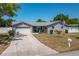 Charming single-story home featuring a two-car garage, a well-kept lawn, and a welcoming front porch at 210 Citrus Dr, Winter Haven, FL 33884