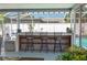 Covered outdoor poolside bar with seating offering the perfect entertaining venue at 210 Citrus Dr, Winter Haven, FL 33884