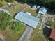 Aerial view of a residential property with a metal roof, green lawn, and accessory buildings at 219 Willow St, Lake Wales, FL 33859