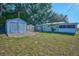 Large backyard with storage sheds, mature trees, and green grass offers plenty of outdoor space at 219 Willow St, Lake Wales, FL 33859