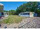 Backyard with grass and storage sheds, along with mature trees, provides functional outdoor space at 219 Willow St, Lake Wales, FL 33859