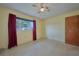 This bedroom has a ceiling fan and a window with red curtains at 219 Willow St, Lake Wales, FL 33859