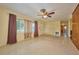 Bright living room featuring a ceiling fan, large windows, and adjacent doorway at 219 Willow St, Lake Wales, FL 33859