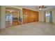 Spacious living room with a ceiling fan, wood paneling and an open archway at 219 Willow St, Lake Wales, FL 33859