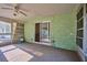 Enclosed sunroom with carpet, ceiling fan, sliding glass door, and cinder block walls provides a great flex space at 219 Willow St, Lake Wales, FL 33859