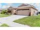 Single-Gathering home with a well-manicured lawn, brown exterior paint, and a two car garage at 249 Haines Blvd, Winter Haven, FL 33881