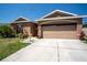 Front exterior of tan house at 249 with driveway and landscaping on a clear day at 249 Haines Blvd, Winter Haven, FL 33881