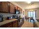 Traditional style kitchen features wooden cabinets, black appliances and neutral countertops with access to dining area at 249 Haines Blvd, Winter Haven, FL 33881