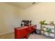 Office with a large red desk, multiple computer screens, rolling chair, and a potted plant on a wooden shelf at 249 Haines Blvd, Winter Haven, FL 33881