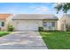 Single-story home featuring an attached garage, neutral paint, well-maintained landscaping and long driveway at 259 Mariposa, Winter Haven, FL 33884
