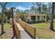 Attractive home exterior featuring a wooden ramp, mature trees, and lush landscaping at 259 Mariposa, Winter Haven, FL 33884