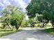 Residential street with mature trees, lush landscaping, and glimpses of neighboring homes at 259 Mariposa, Winter Haven, FL 33884