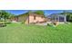 The backyard of this home has a concrete patio, landscaping, and a pool enclosure at 2611 State Road 557, Lake Alfred, FL 33850