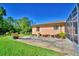 Backyard with a patio area surrounded by lush green grass and landscaping at 2611 State Road 557, Lake Alfred, FL 33850